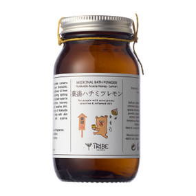 Tribe Skincare Japanese Bath Powder with Hokkaido Acacia Honey & Lemon - 200-Grams glass jar with yellow powder and white label; for people with acne-prone, sensitive and inflamed skin